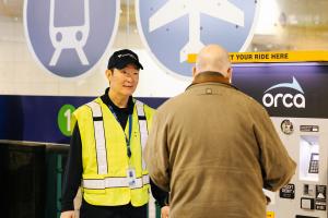 A station agent helps a passenger at Westlake Station