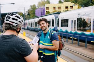 A Sound Transit staff ambassador helps a passenger at a Link station