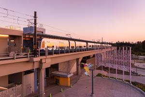The sky takes on a pink and purple glow behind the elevated Lynnwood City Center Station