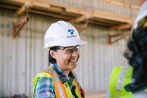 Deputy Executive Project Director Eza Agoes wears a white hard hat and yellow vest while on a construction site.