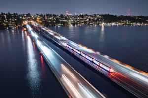 The blur of a train crosses the I-90 bridge in the evening