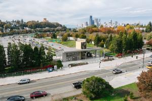 An entrance to Judkins Park Station features art of Jimi Hendrix. I-90 is in the immediate background, with the downtown Seattle skyline further back.