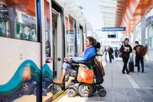 A person in a wheelchair boards a Link train