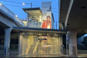 Crosstown Traffic (It's So Hard To Get Through To You), 2022 Hank Willis Thomas  Hank Willis Thomas’ murals at each station entrance celebrate Seattle native Jimi Hendrix, capturing both the hope of youth and the fleeting nature of success. At the west station entrance, the 50-foot-tall mural is based on a snapshot taken soon after Hendrix’s first teenage gig. At the east station entrance, Thomas’ mural is a collage of portraits taken at the peak of Hendrix’s fame, rendered in gold-toned metal. Each artwork