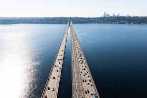 An aerial view of cars and train tracks on the I-90 floating bridges on Lake Washington
