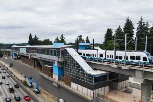 A Link train pulls out of the elevated Pinehurst Station next to I-5