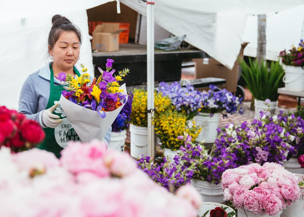 A flower vendor puts together bouquets at the Tacoma Farmers Market