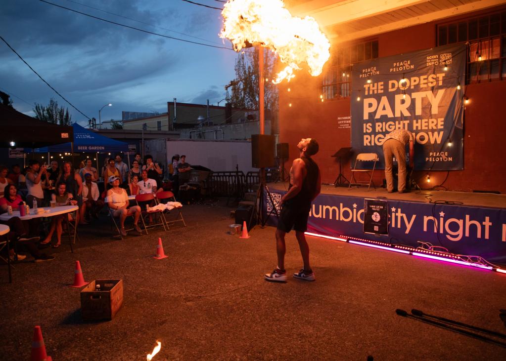 A crowd watches on as a performer uses fire to entertain