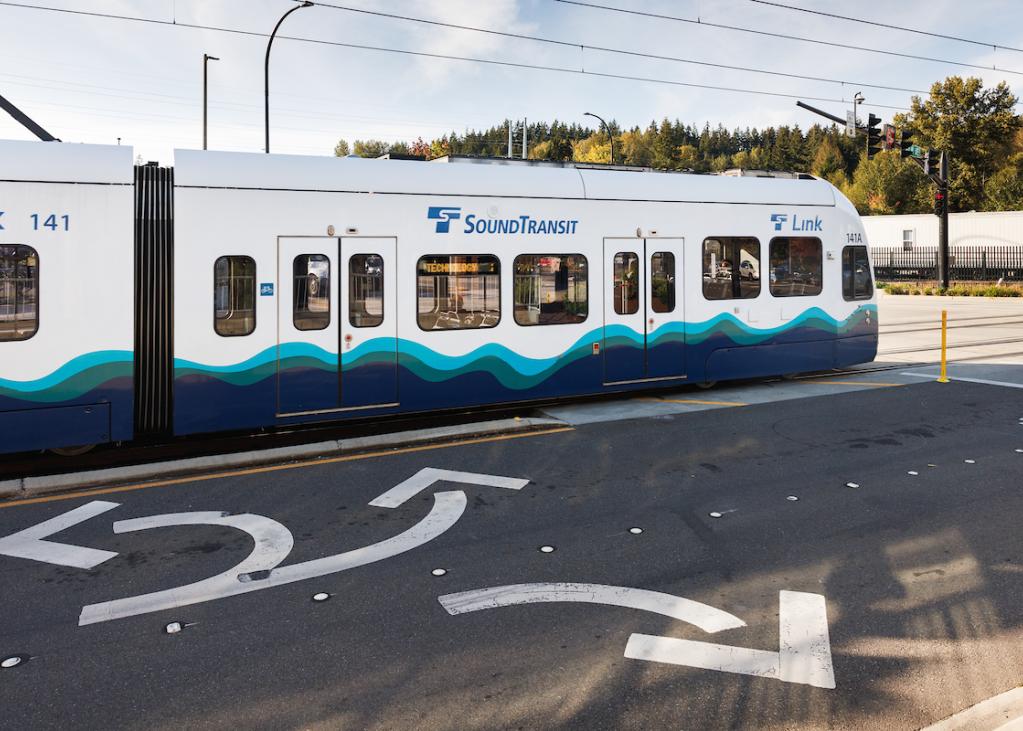 The first car of a Link light rail train in at grade section of track in Bellevue