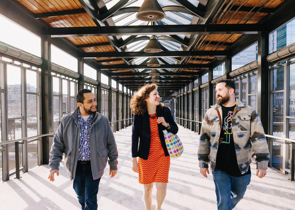 A group of people walk and smile wearing Sound Transit shop items