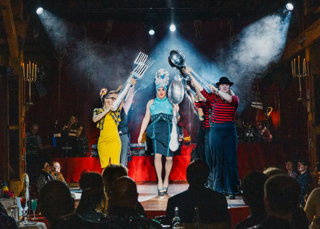 A crowd looks on as the spotlight shines on Teatro performers.