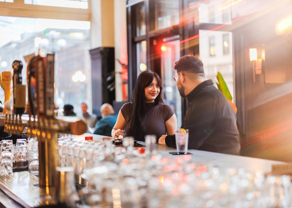 A couple sits at the bar at Good Bar.