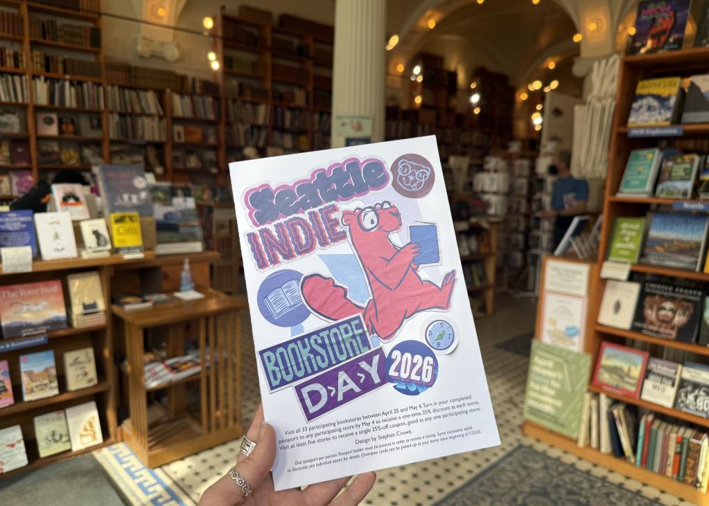 The cover of the passport for Seattle Independent Bookstore Day 2026 features a cartoon animal reading a blue book
