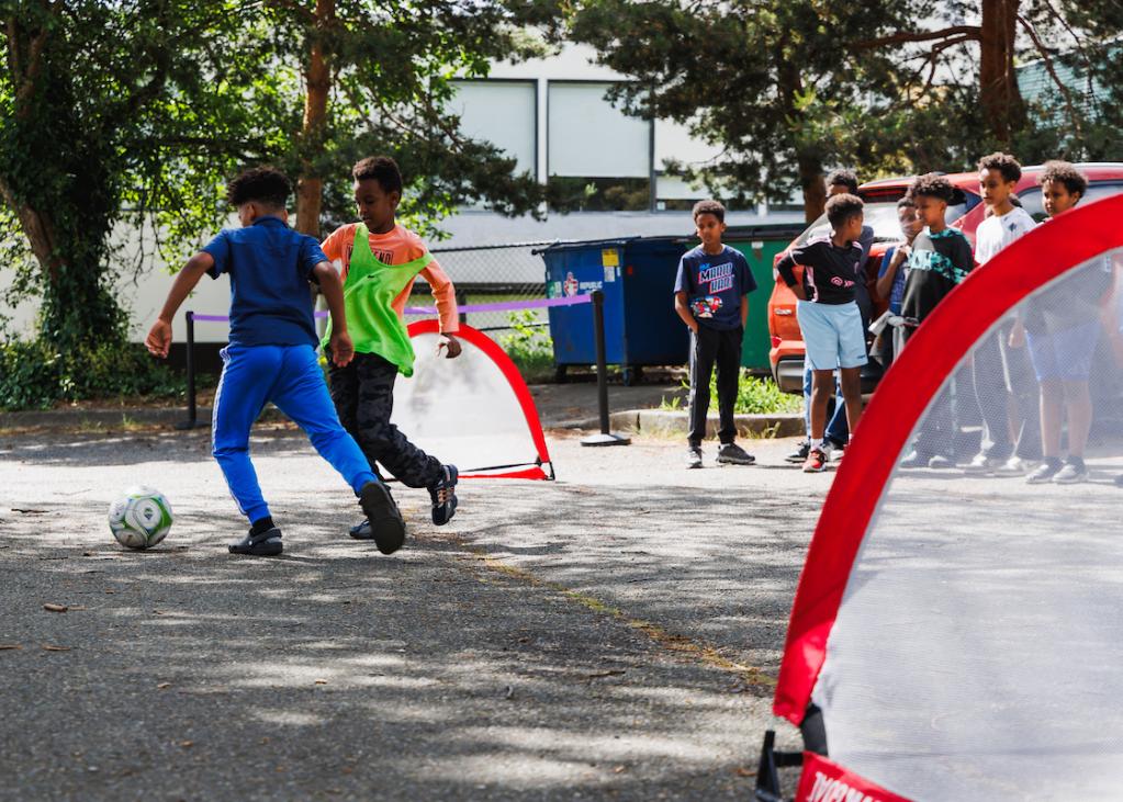 Two young people play soccer with pop-up goals 