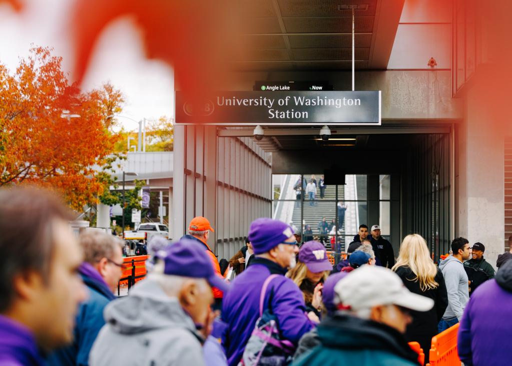 Fans walk from University of Washington Station into the football stadium