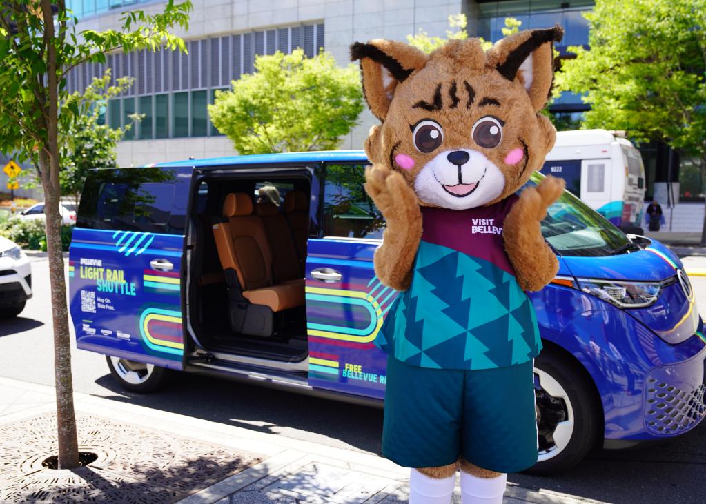 A bobcat mascot in front of a blue shuttle 