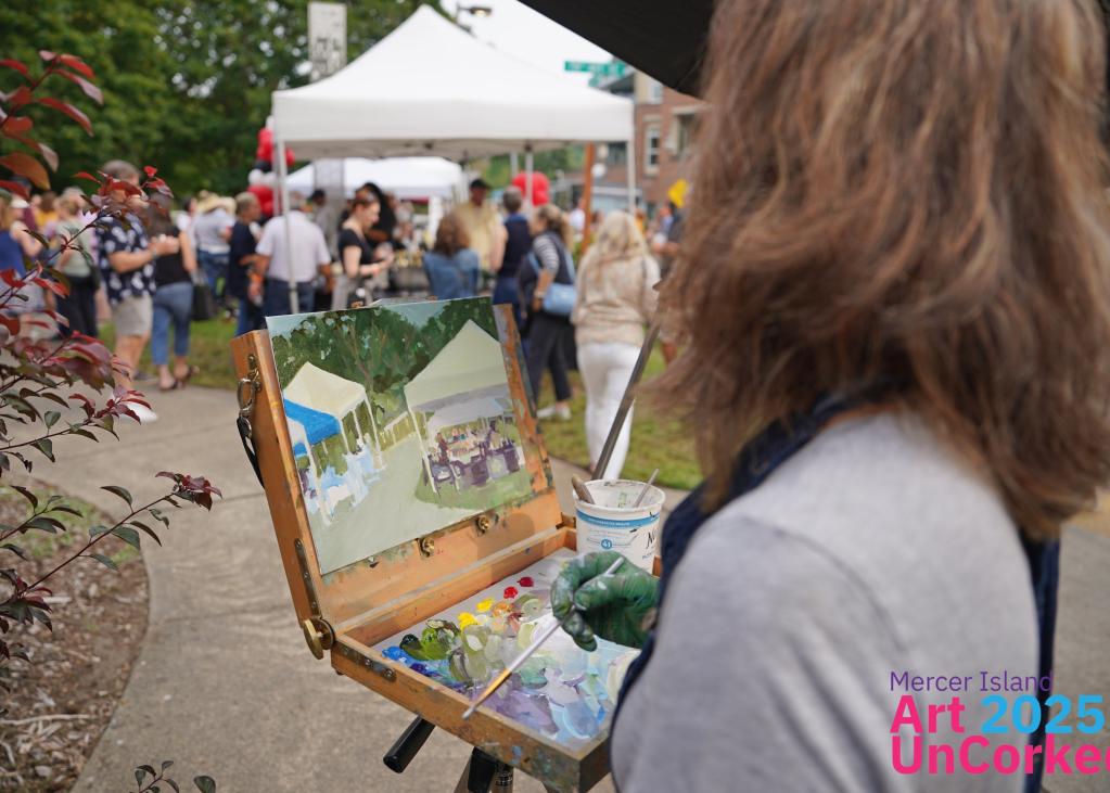A painter and their easel in front of a crowd of people