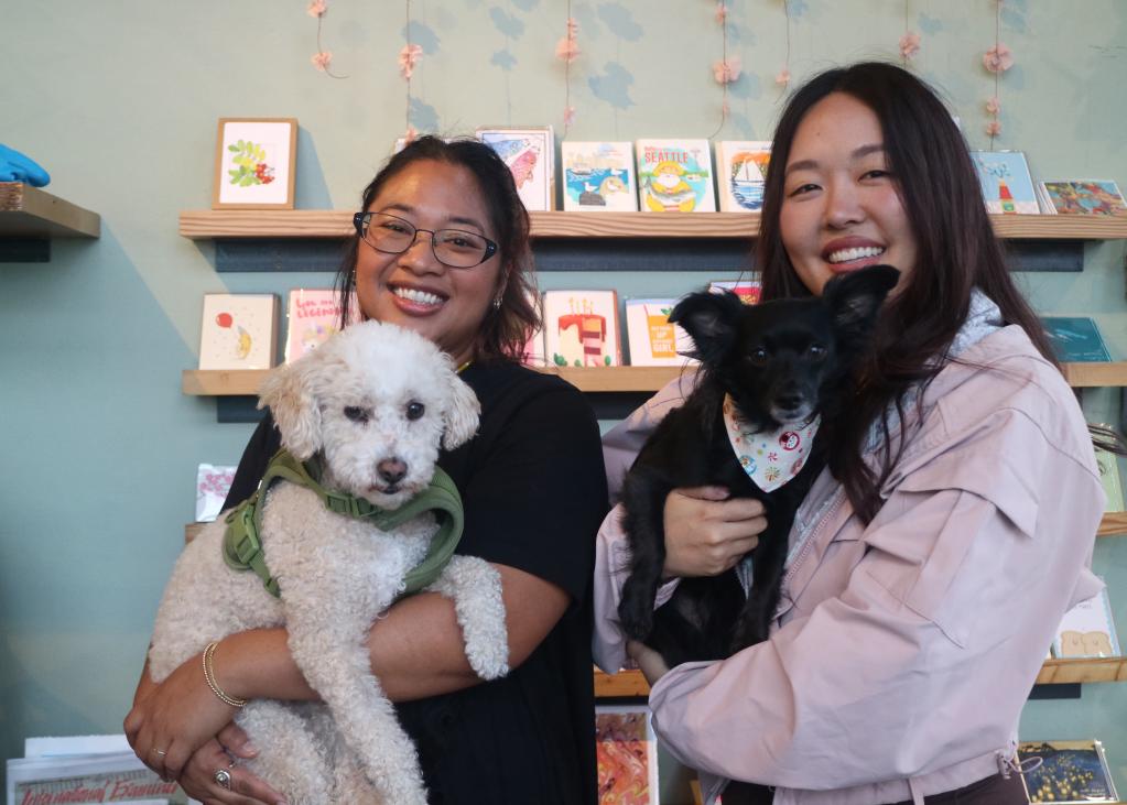 Two people hold dogs in the store Sairen in Seattle's Filipino Town