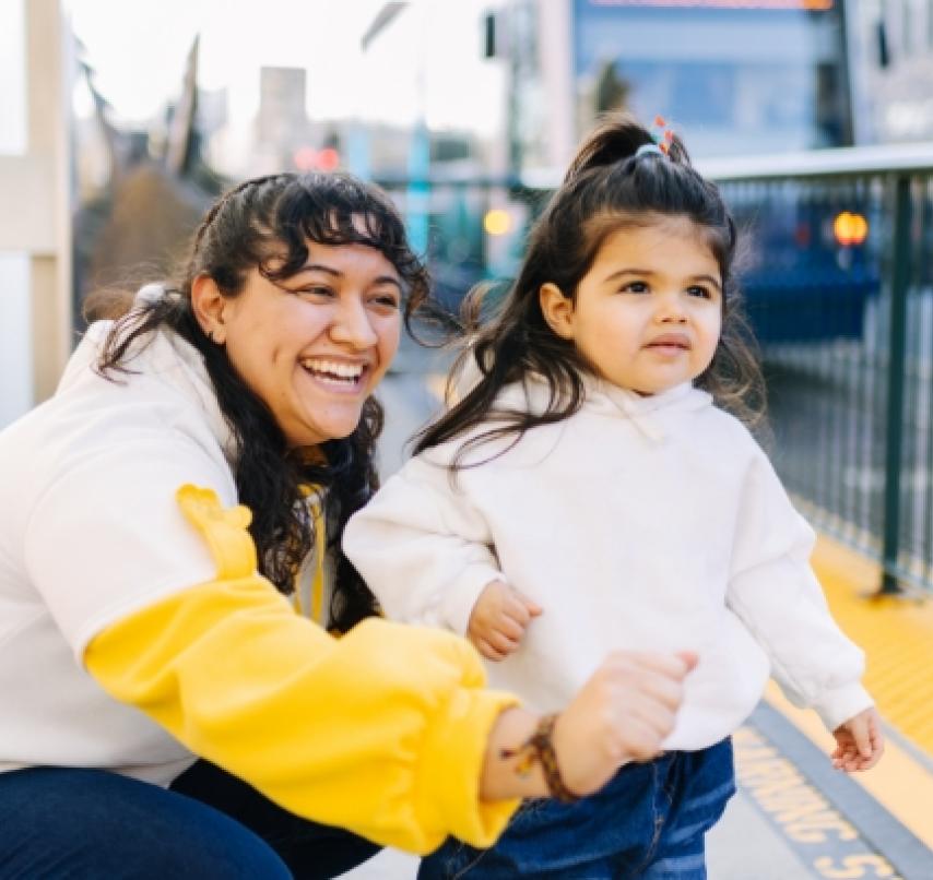 A woman and a child waiting for a Link light rail train to arrive.