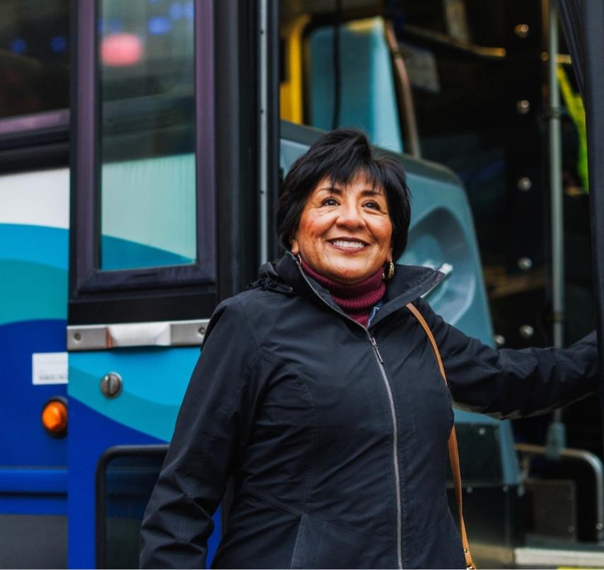 A rider smiles in front of an ST Express bus.