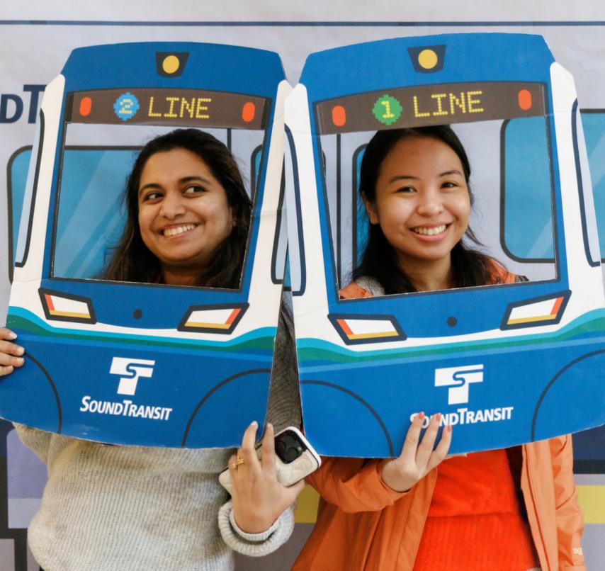 Two riders pose with the faces framed in cardboard cutouts of Link trains 