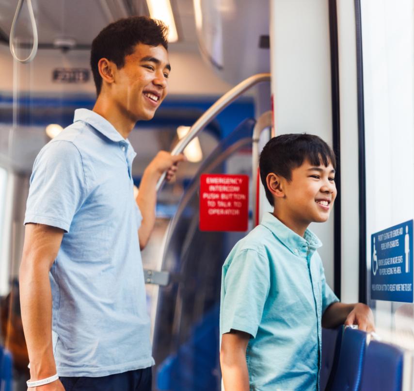Riders, one adult and one child, look out the window as they travel on the Link. 