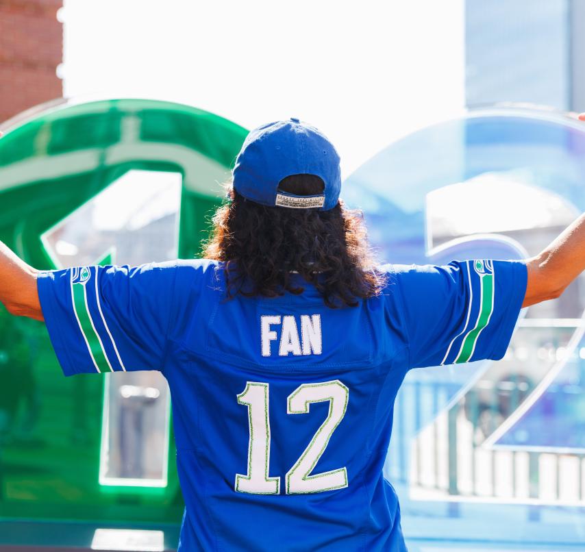 Person in '12' jersey in front of 1 Line signage